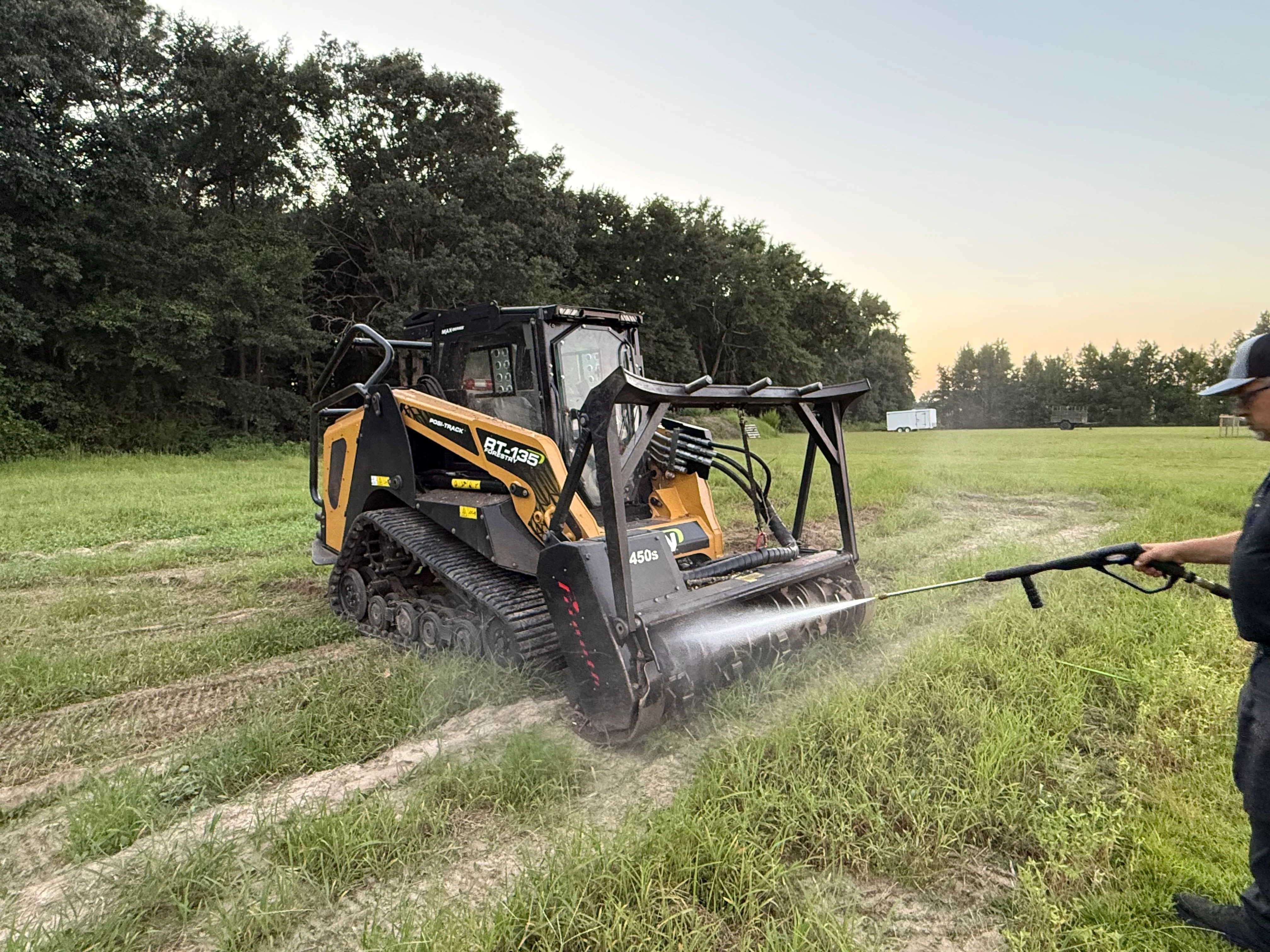 Compact track loader with drum roller compacting driveway base material